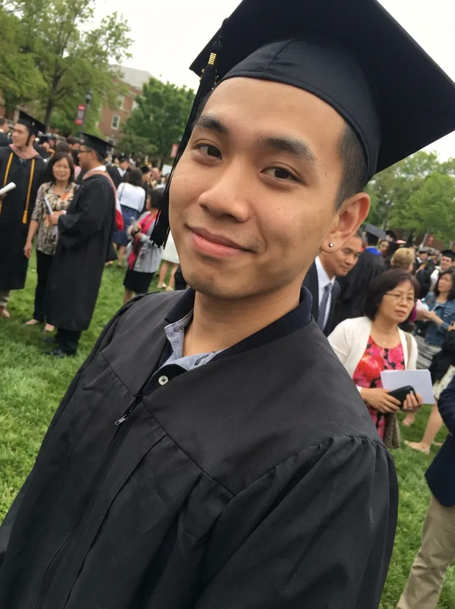 Original selfie input — smiling man in cap and gown at graduation